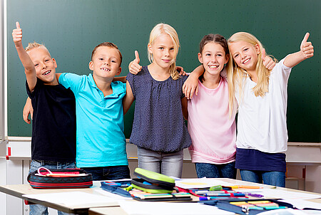 Fröhliche Schulkinder im Klassenraum Gruppe fröhlicher Schulkinder im Klassenraum